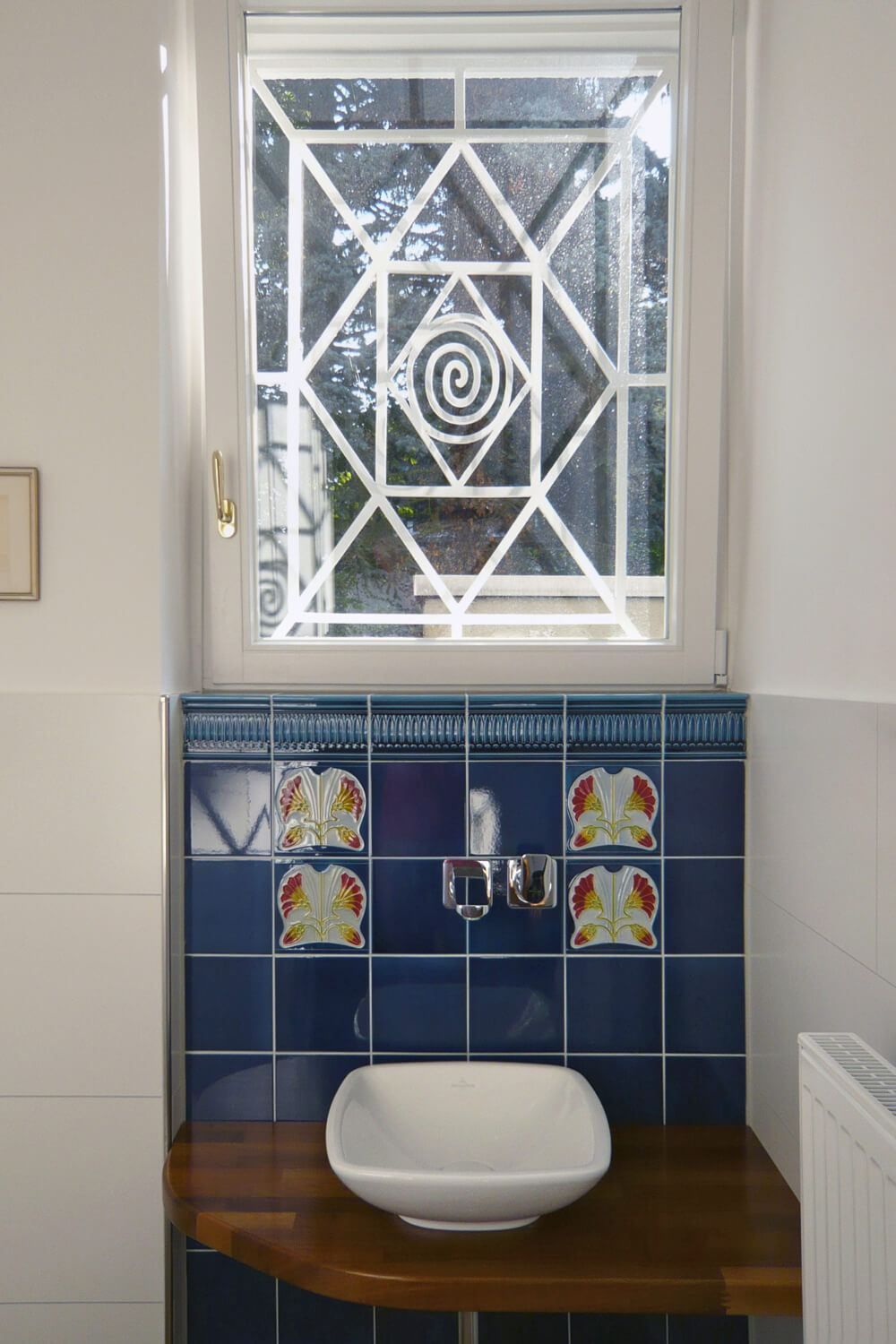 Fliesenspiegel in Bad mit blauen Fliesen, blauer Bordüre und Jugendstilfliese in blau und rot von GOLEM. Entwurf: Tonwerke Offstein 1900